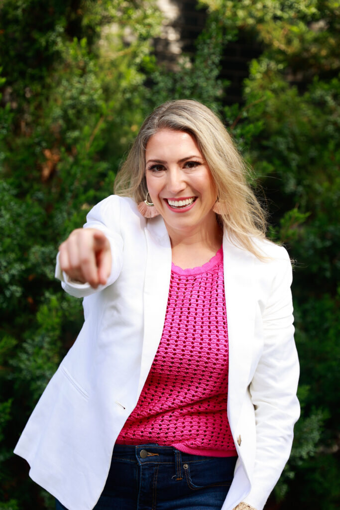 Building your rebrand dream team should start with a business coach. Professional woman pointing at camera. 