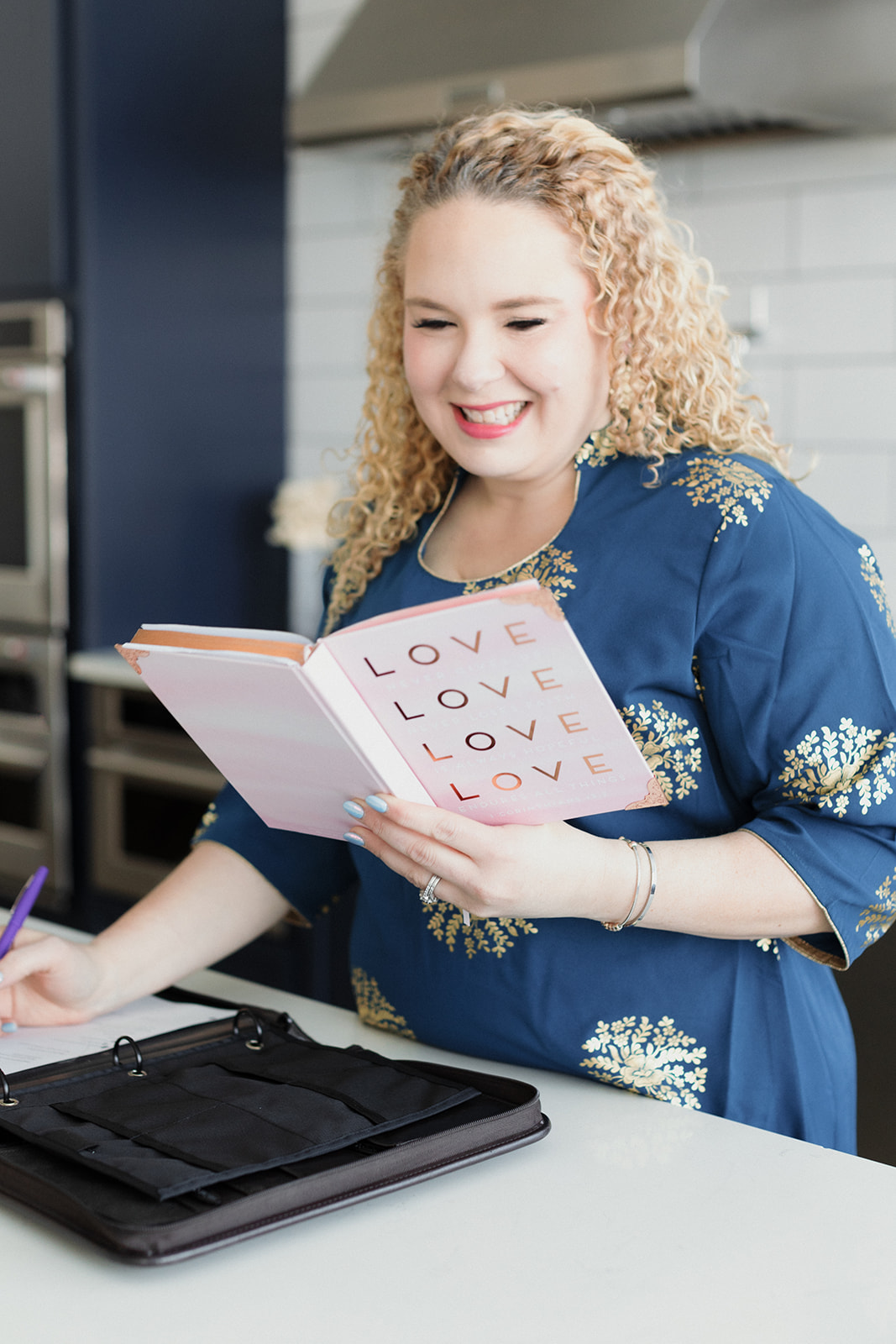 woman reading book about love as she writes a wedding ceremony