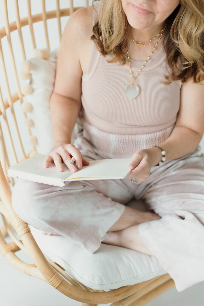 woman sitting in wicker chair and journaling, you need a strategy for your brand photos