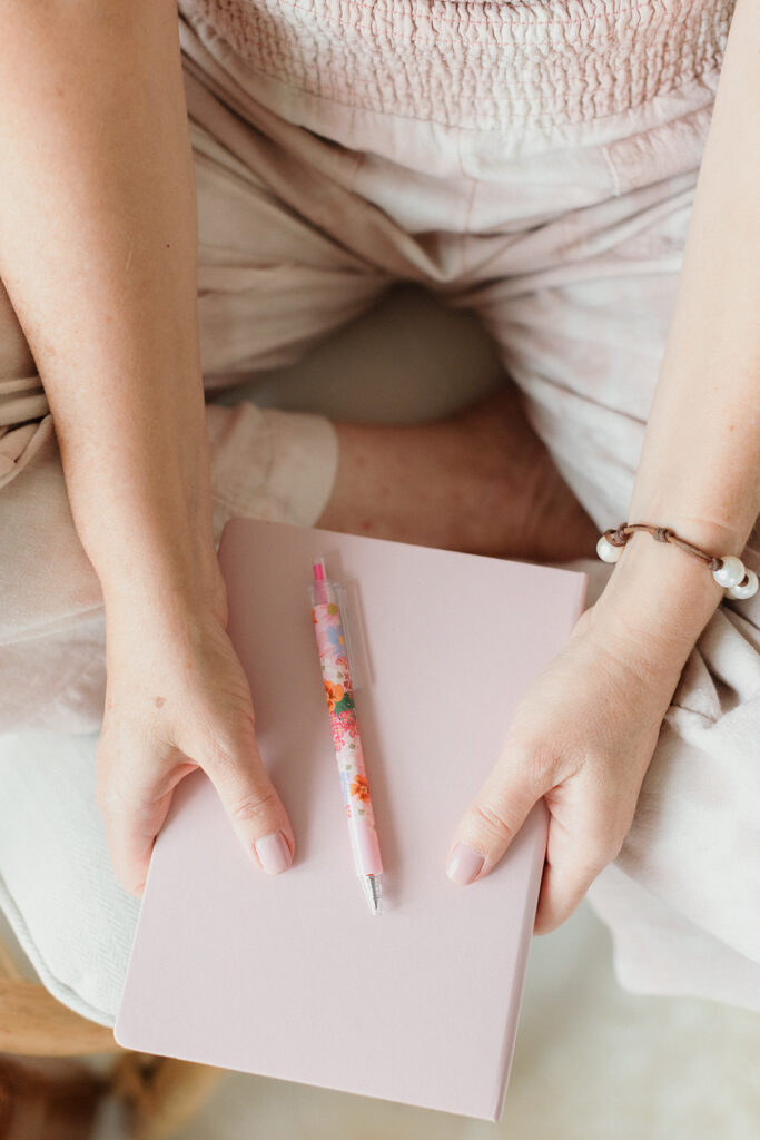 woman holding journal and pen, you need a strategy for your brand photos