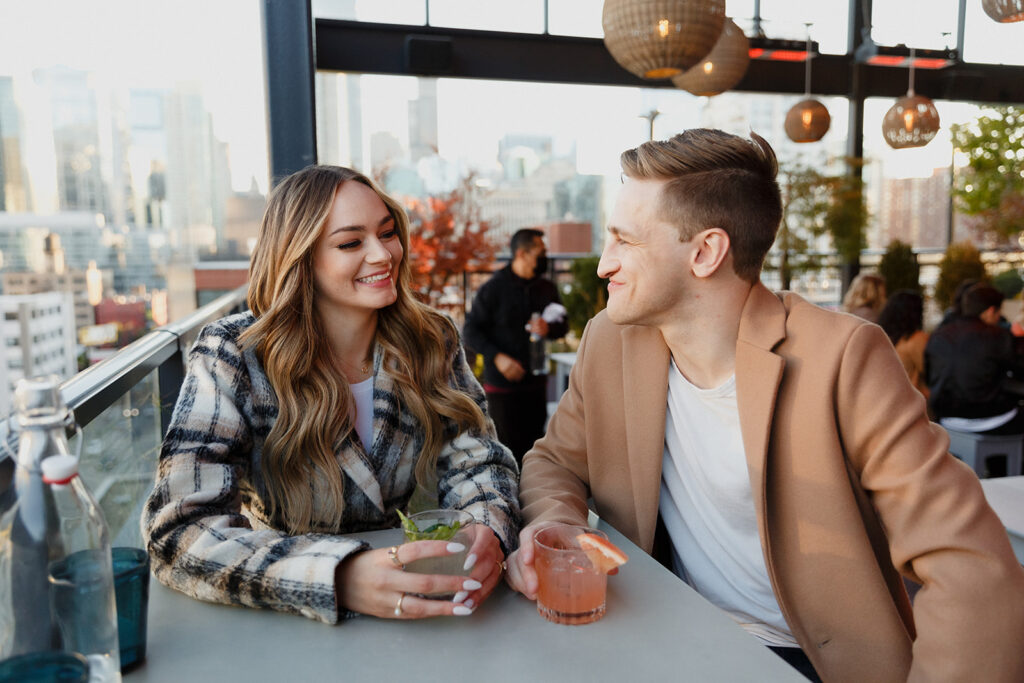 couple having drinks on the Bar Avec rooftop in Chicago Romantic River North engagement session