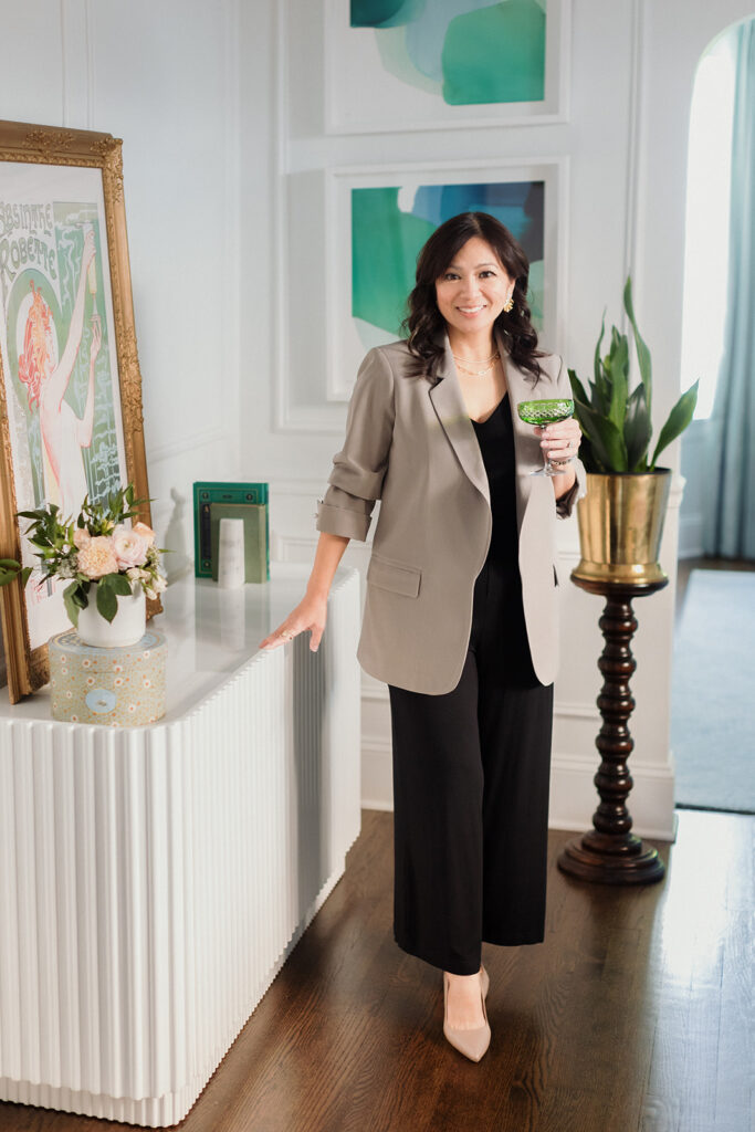 What to Wear for Your Brand Shoot calligrapher, woman standing casually in a dining room with a glass of vintage champagne , Chicago brand photography