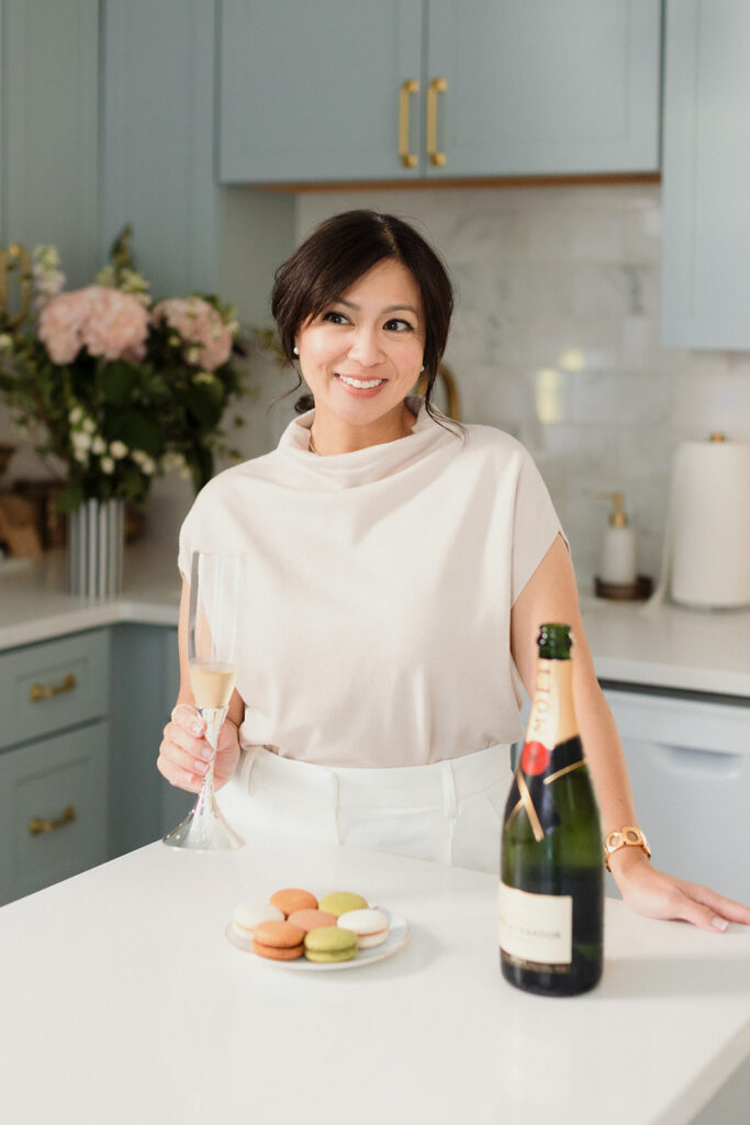 What to Wear for Your Brand Shoot calligrapher, woman in blue kitchen sipping champagne from a flute with macarons , Chicago brand photography