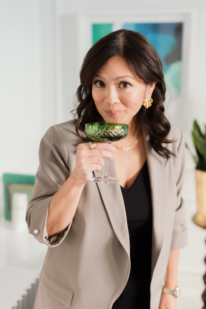 What to Wear for Your Brand Shoot calligrapher, woman coyly looking at camera before sipping champagne out of a vintage glass , Chicago brand photography