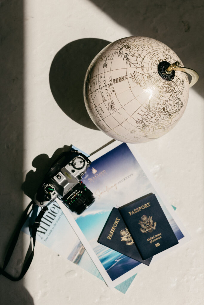 Travel brand photography flat lay featuring passport, maps and camera props for Bridie Travel by Lisa Kathan