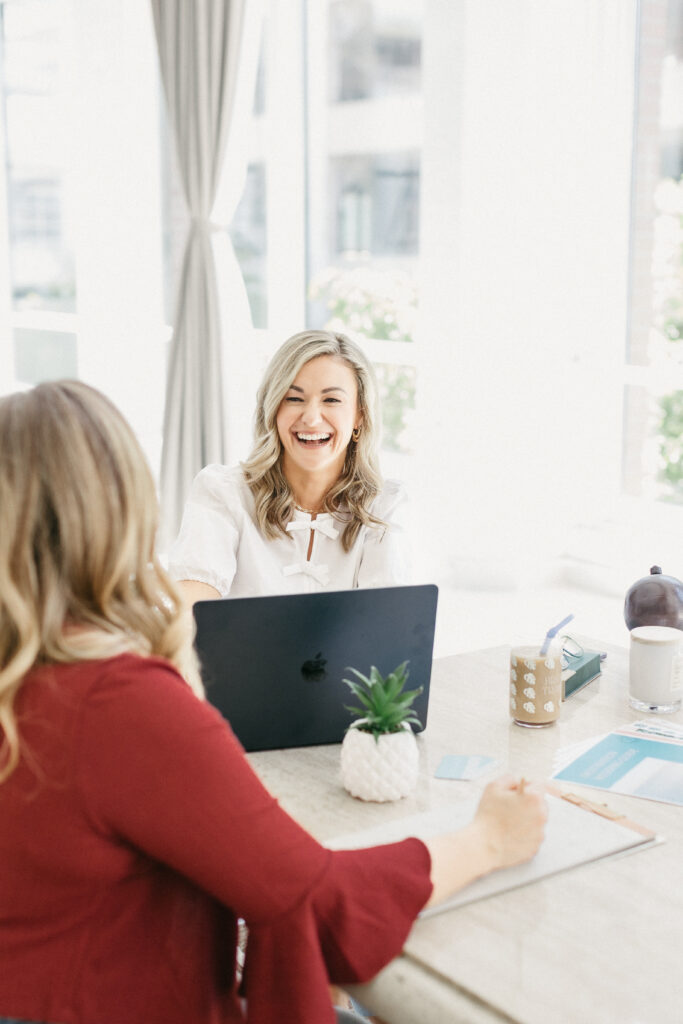 Luxury travel planner Megan working at her desk during brand photography session with Lisa Kathan