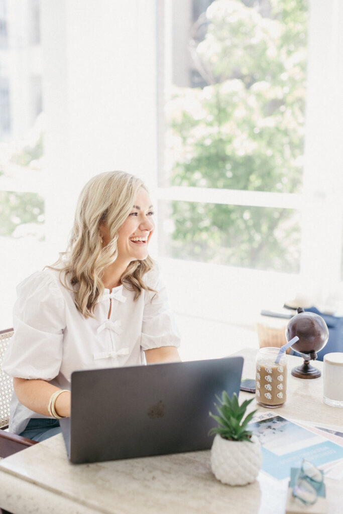 Luxury travel planner Megan working at her desk during brand photography session with Lisa Kathan